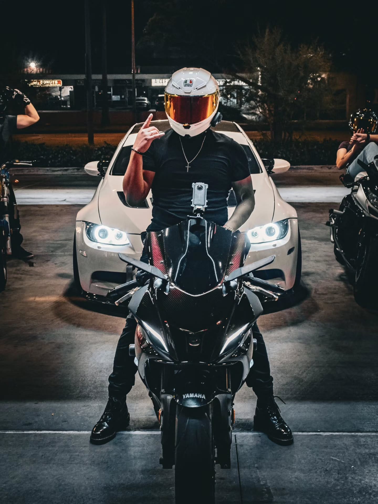 Rider in a white helmet in front of a BMW at the pumps