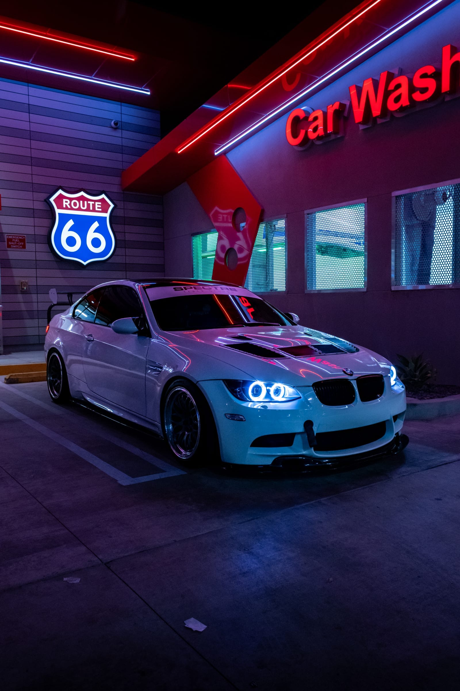 Javi's white BMW M3 under the car wash neon