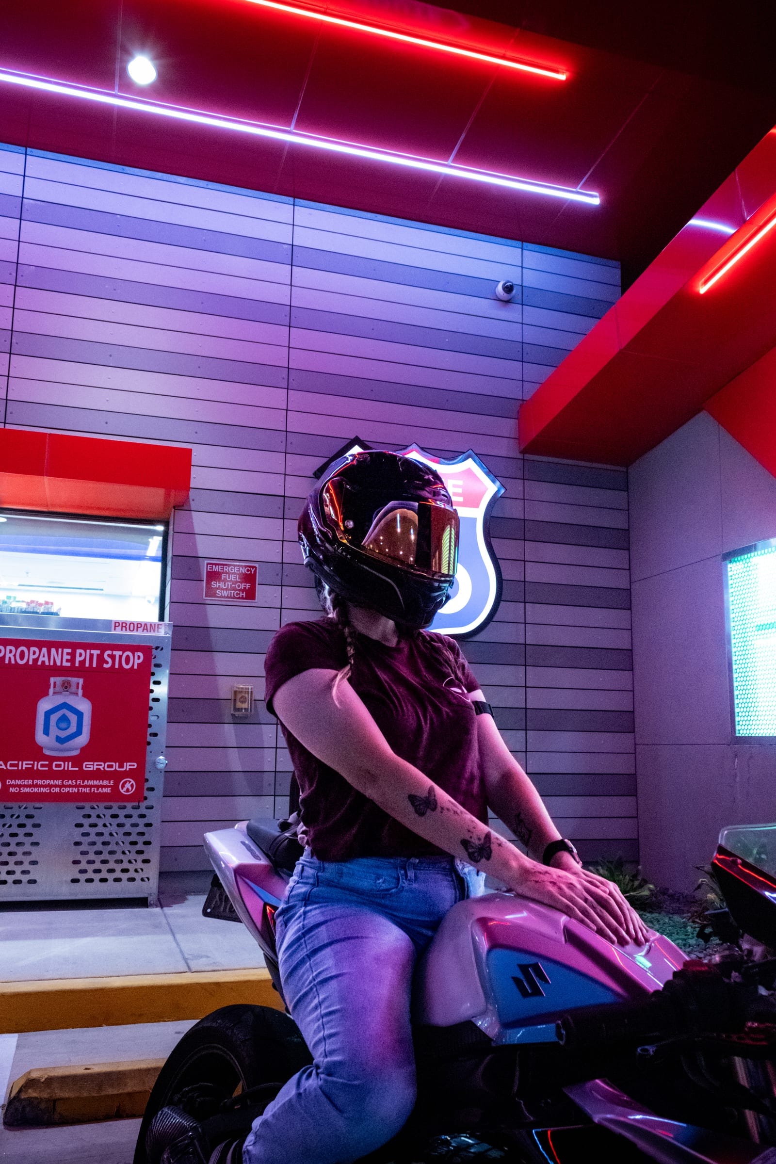 Kit with her Suzuki under Route 66 neon