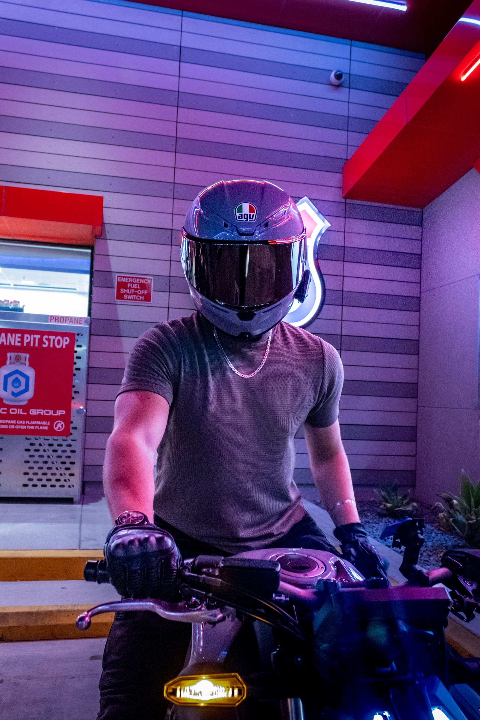 Safety Sam seated on a Honda under neon