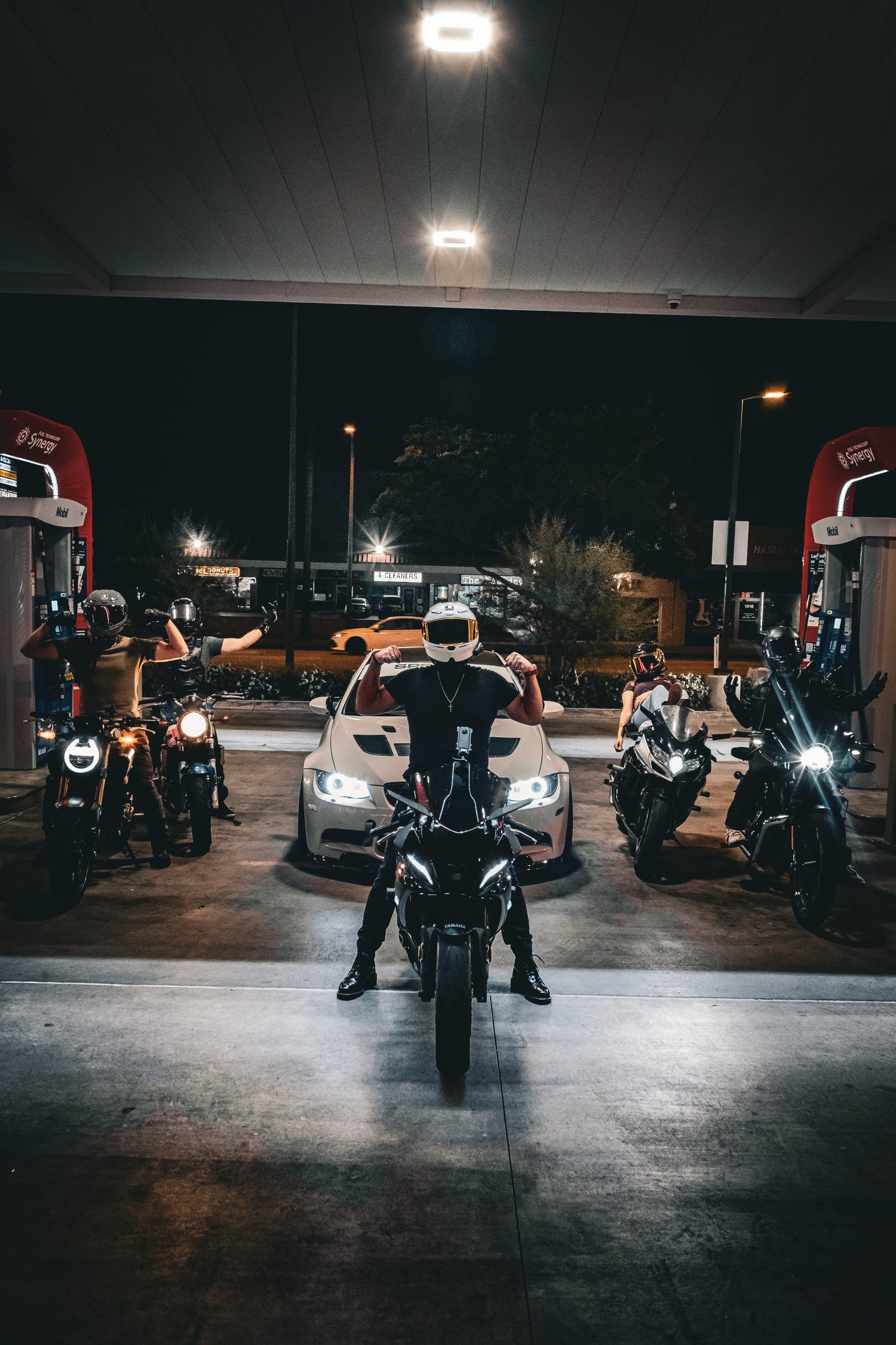 The lineup under the canopy lights, seen from the forecourt