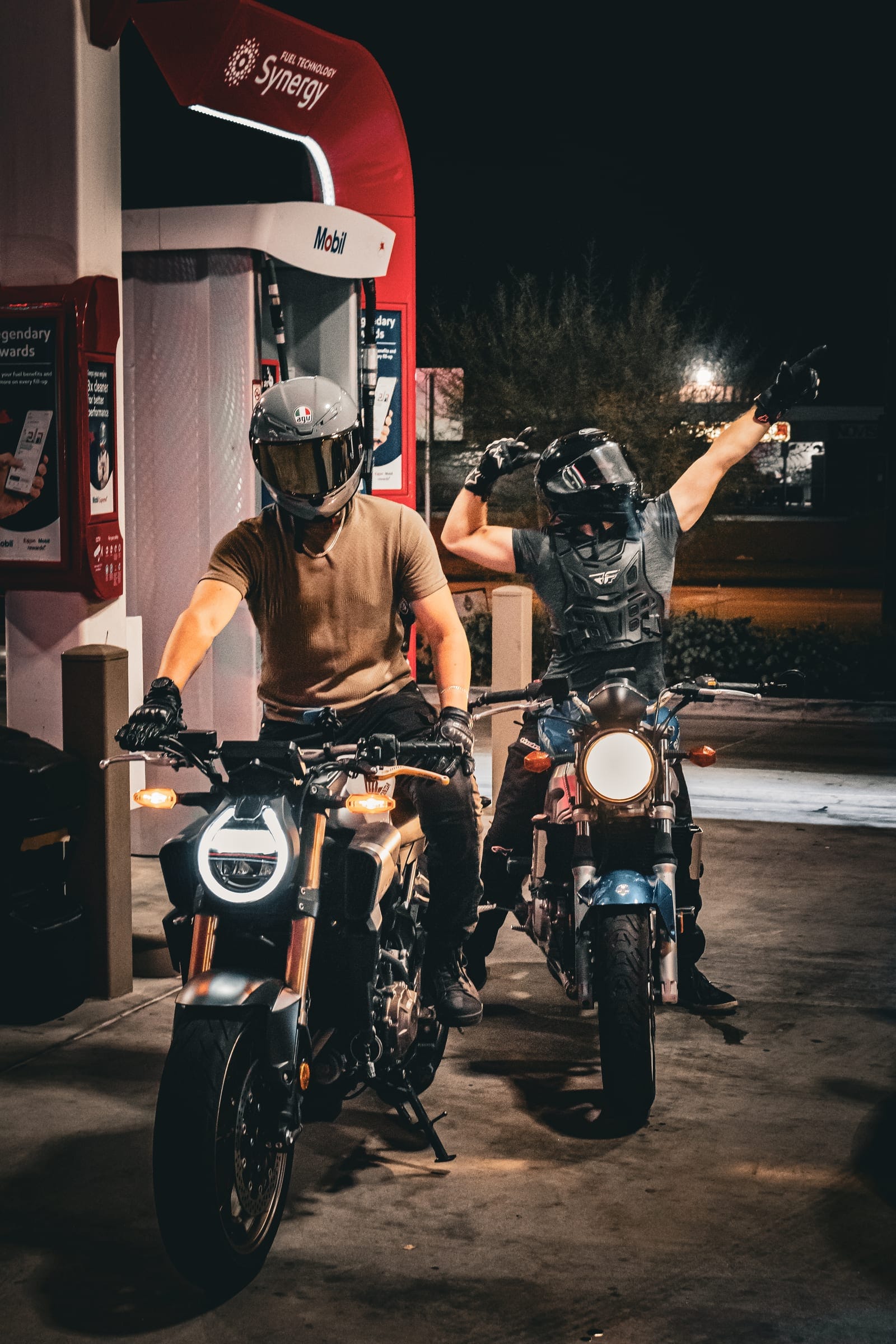 Two riders and their bikes at the pumps