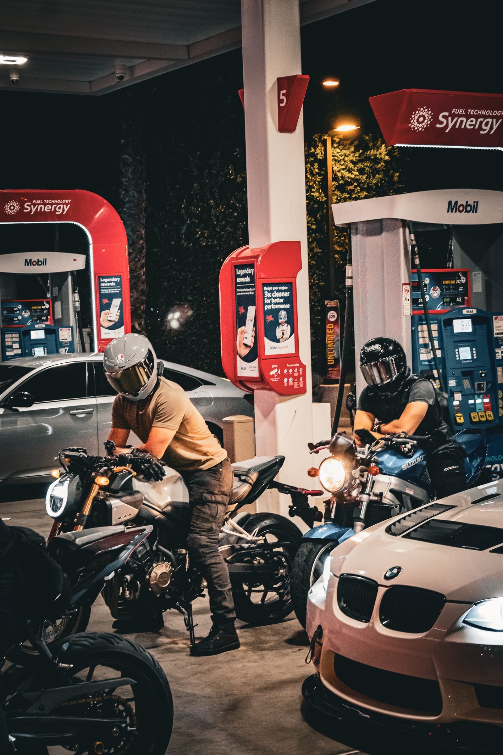 Riders at the pumps beside the white BMW