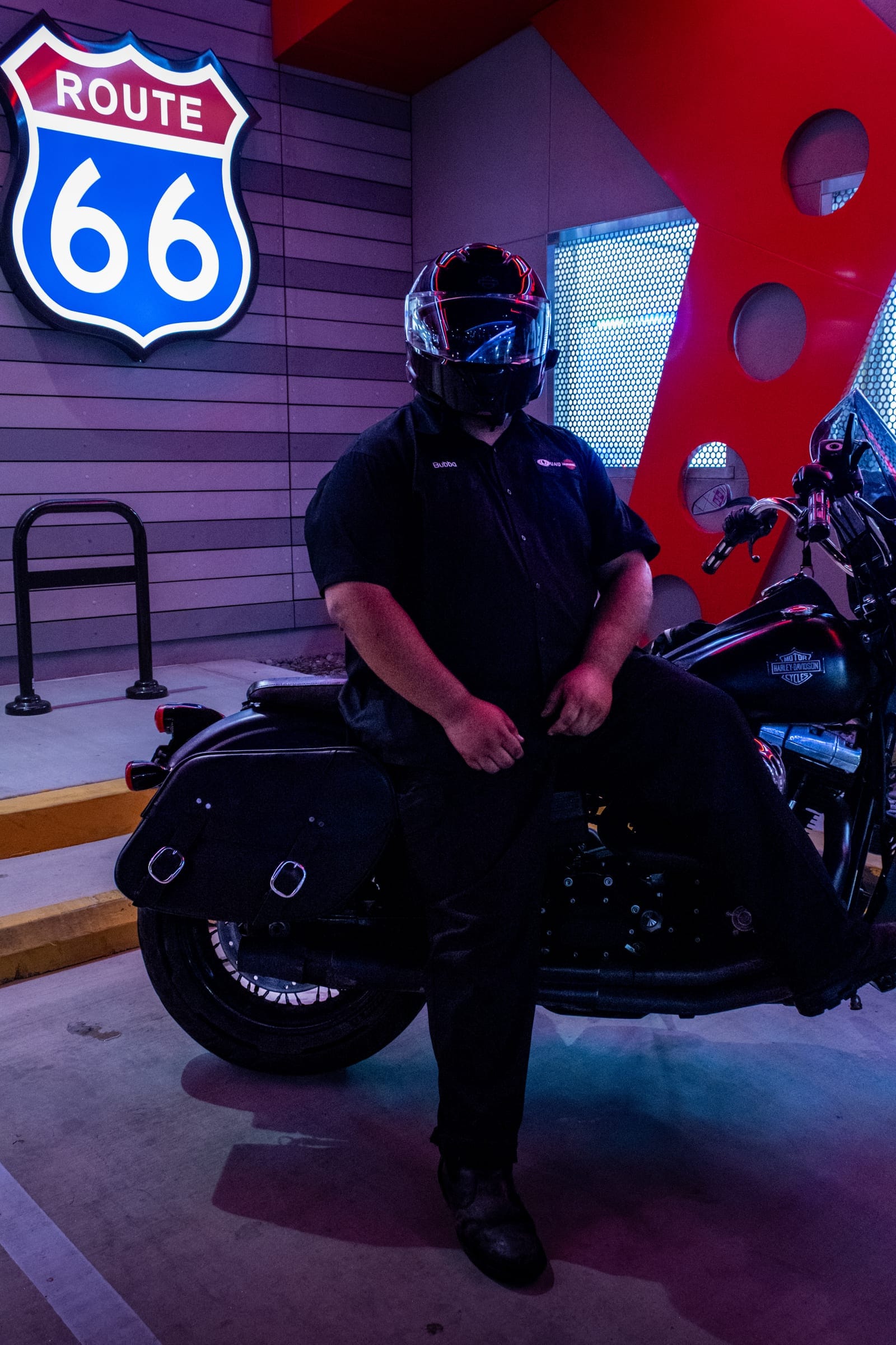 Rider in a dark helmet seated on a black cruiser with saddlebags
